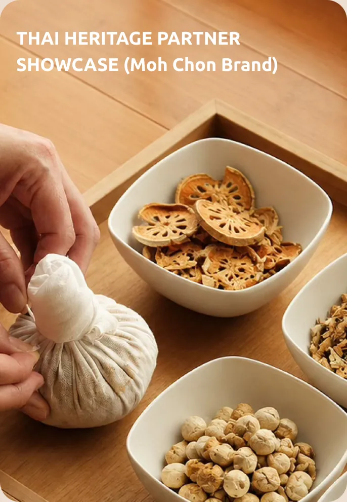 Hands wrapping a Thai herbal compress beside trays of dried herbs and spices